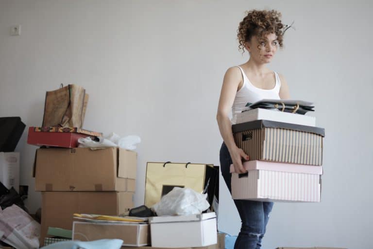femme porte cartons de rangement à stocker pour désencombrer maison