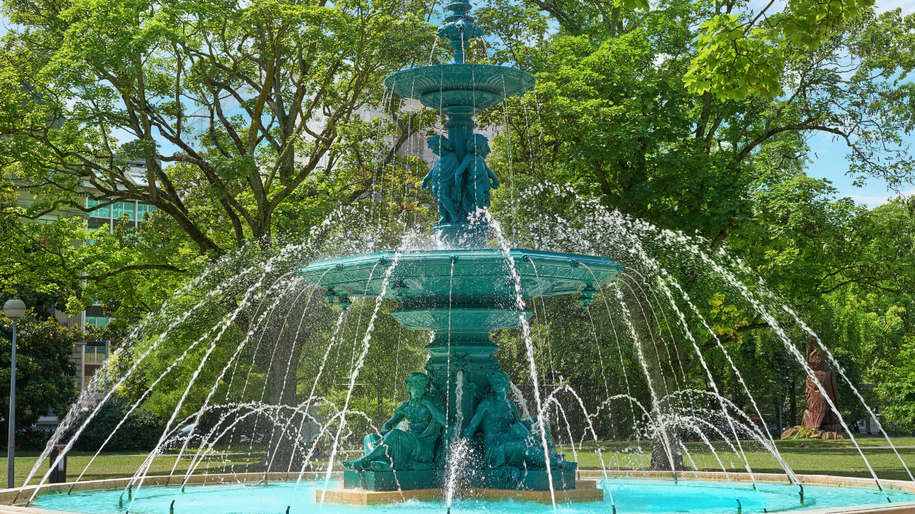 Une fontaine en métal dans un jardin