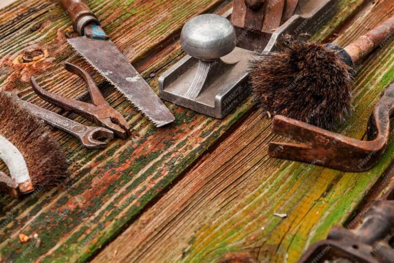 vinaigre blanc : bouteille de vinaigre blanc à côté d'outils rouillés en cours de nettoyage